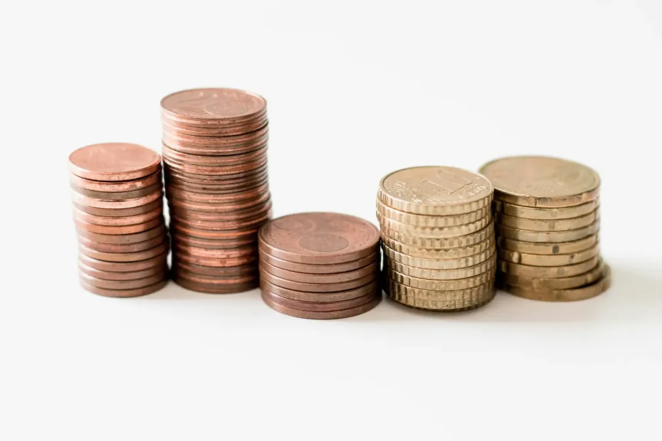 Imagem de moedas de cobre e ouro empilhadas, simbolizando organização financeira e estabilidade econômica.