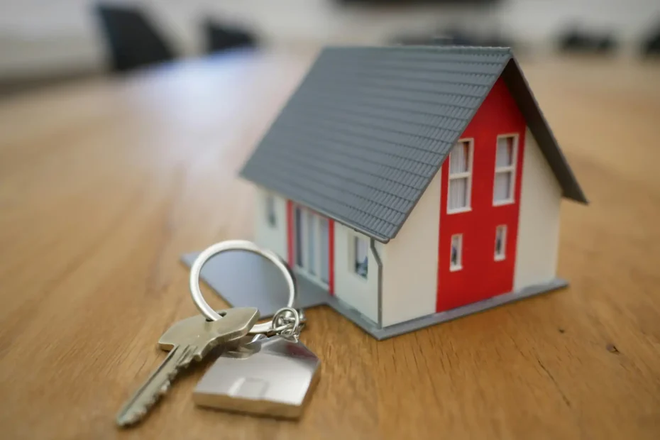Imagem de uma casa em miniatura com chave e porta ao lado, representando o mercado imobiliário, tendências, desafios e oportunidades para os próximos anos.