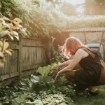 Pessoa cuidando de uma horta caseira em um espaço pequeno com plantas verdes, ideal para quem quer aprender como montar uma horta caseira em pequenos espaços