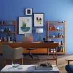 Sala de escritório moderna com decoração em tons de azul, móveis de madeira e obras de arte na parede, refletindo tendências de decoração para 2025.