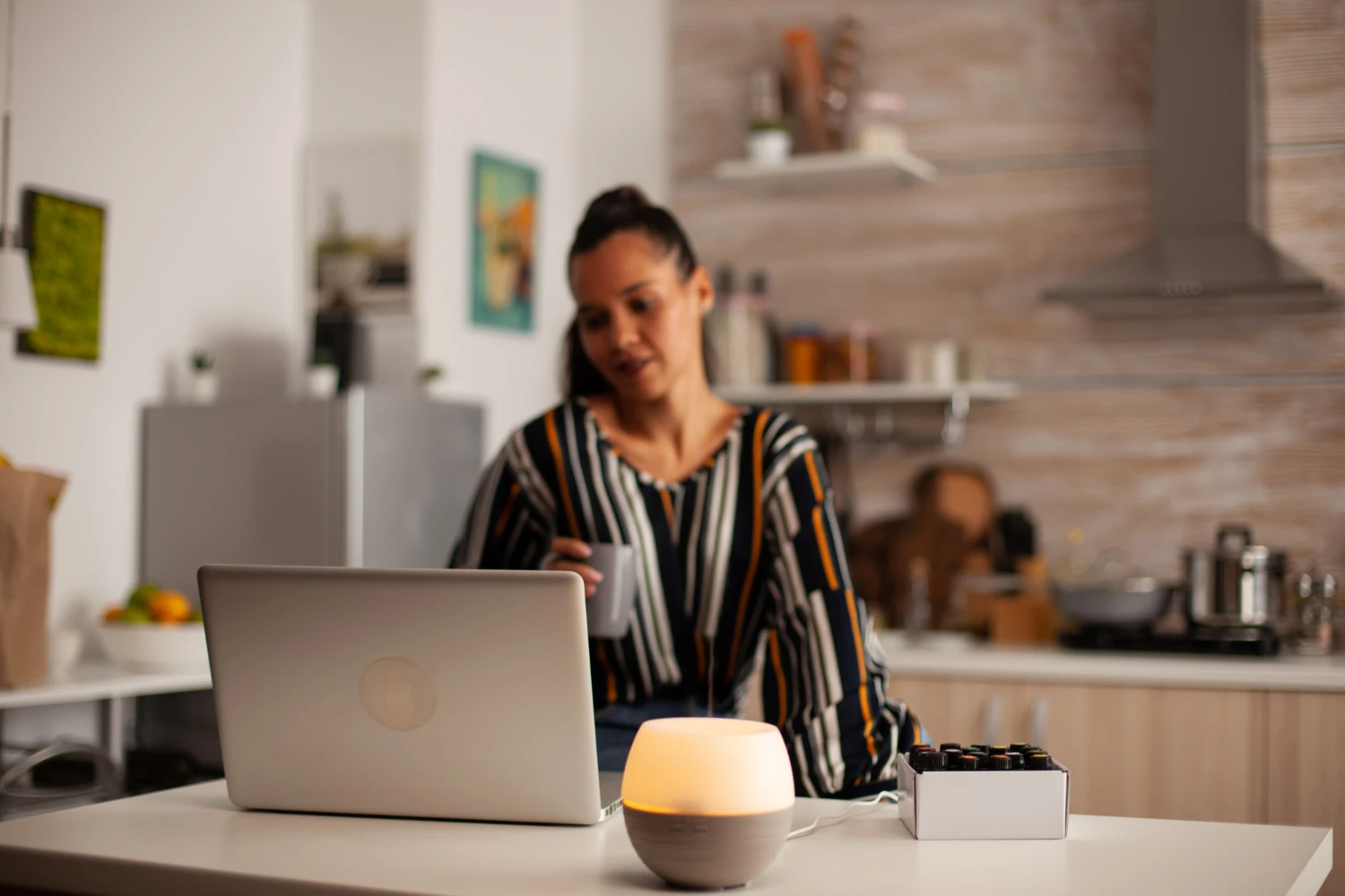 Mulher em home office ajustando postura para ergonomia doméstica, com notebook e iluminação adequada, promovendo saúde e conforto no trabalho remoto.